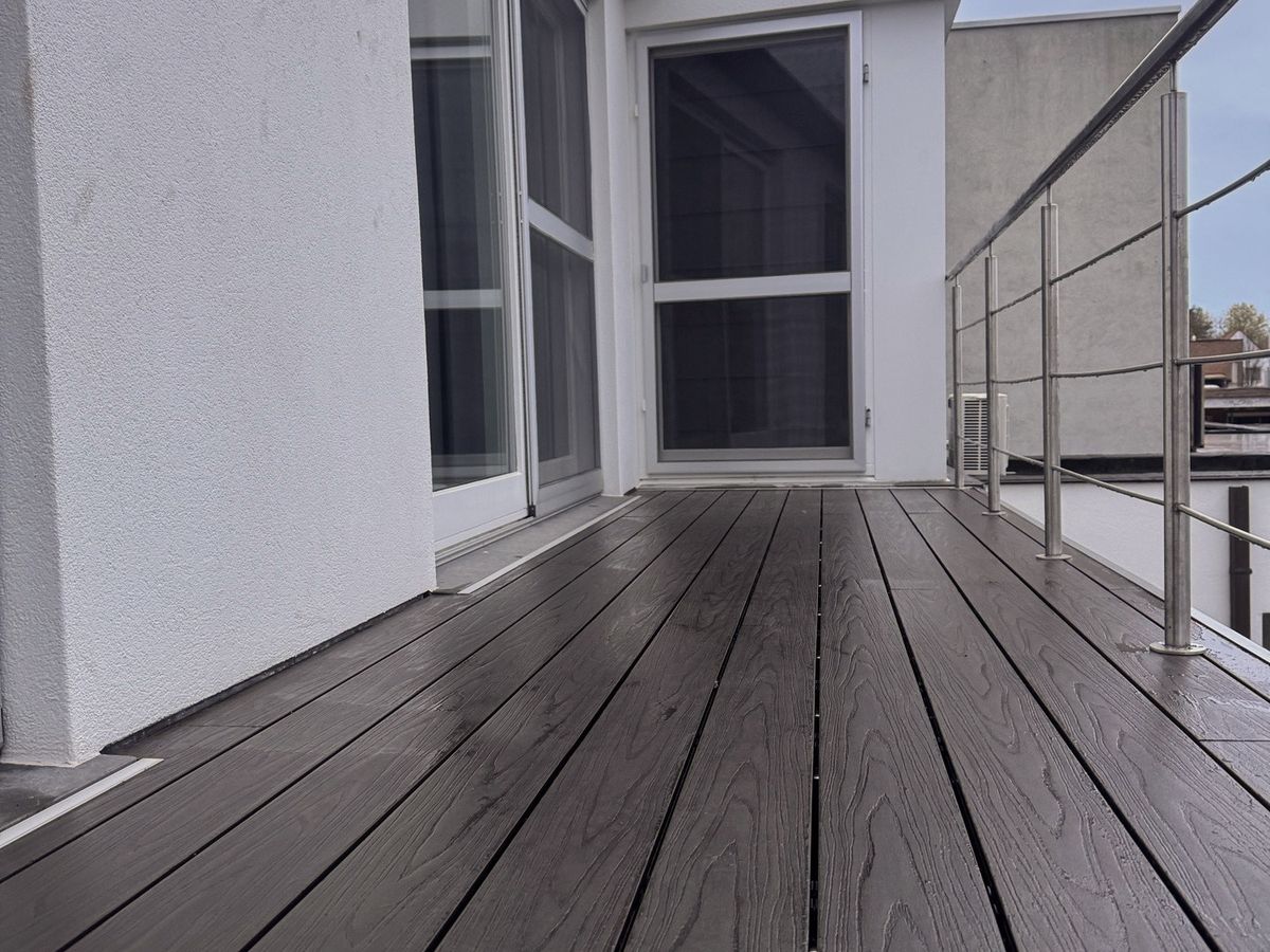 Dakterras in EvoWood-planken in de kleur taupe, langs de gevel en een reling in inox