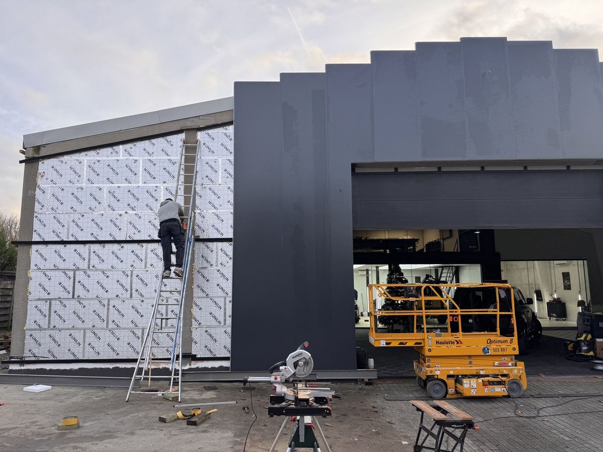 Onze ploeg bekleedt de voorgevel: links nog isolatie, rechts al panelen
