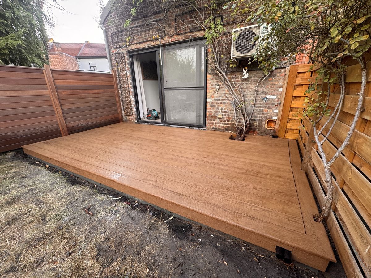 Het afgewerkte terras in Millboard-planken schuin gezien, in een tuin in Leuven