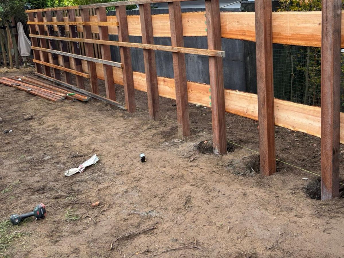 De palen met de regels van de tuinwand, op een rij tijdens de werken